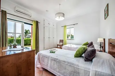 a bedroom with two beds and a large window at Villa Luis in Galé