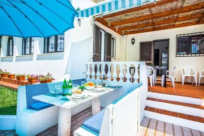a patio with a table and chairs and a house at Villa Toad Hall in Galé