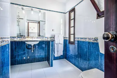 a blue and white bathroom with a sink and a mirror at Villa Toad Hall in Galé