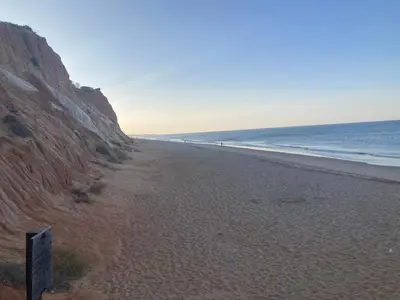 a beach next to the ocean next to a cliff at Praia Village AG in Vilamoura