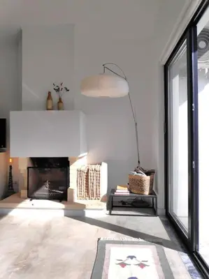 a living room with a fireplace and a large window at Airy 3br, AC, Garden, 2min Strip, 8min Oura Beach in Albufeira