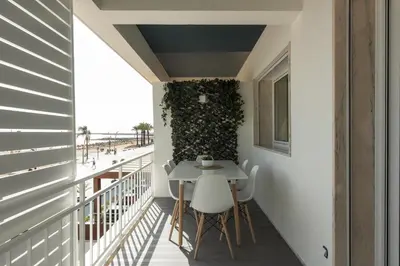 a small balcony with a table and chairs on it at Miral 5 Sea front by HD Properties in Quarteira