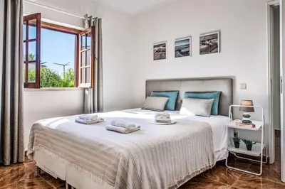 a white bedroom with a large bed and a window at Villa Mar Gale in Galé