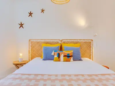 a bedroom with a bed with blue and yellow pillows at AL - Vilamoura Algardia in Vilamoura