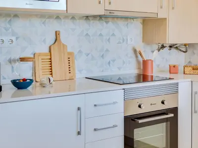 a kitchen with white cabinets and a counter top at AL - Vilamoura Algardia in Vilamoura