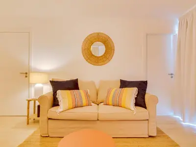 a living room with a couch and a mirror at AL - Vilamoura Algardia in Vilamoura