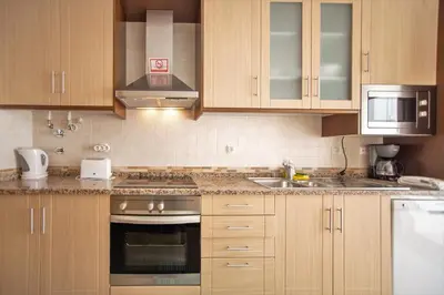 a kitchen with wooden cabinets and a stove top oven at Villa Albufeira by Atlantic Places in Albufeira