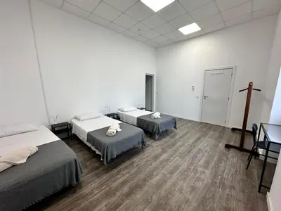 a room with two beds and a cross on the wall at Albergaria Formosa in Faro