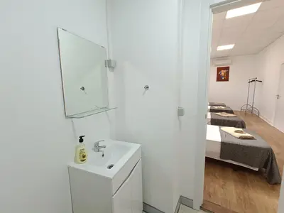 a white bathroom with a sink and a bed at Albergaria Formosa in Faro