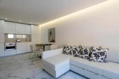 a living room with a white couch and a kitchen at Downtown Art Flat in Albufeira