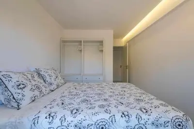 a bedroom with a large bed with blue and white sheets at Downtown Art Flat in Albufeira