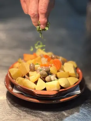 a person holding a piece of food in a bowl of vegetables at Vilamoura Central 7 With Pool by Homing in Vilamoura
