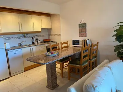 a kitchen with a table and a kitchen with a couch at Solar Dos Pinheiros in Quarteira