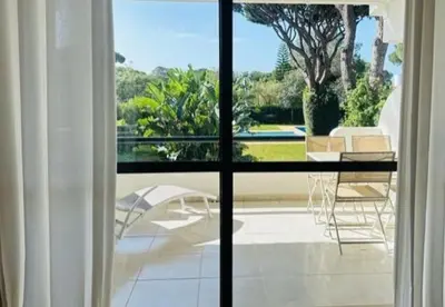 a view of a patio with a table and chairs through a window at Solar Dos Pinheiros in Quarteira