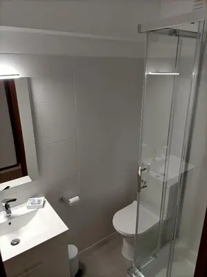 a bathroom with a shower and a toilet and a sink at The Retreat - O Retiro Algarvio in Faro