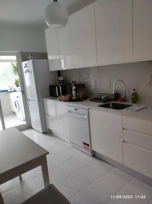 a white kitchen with a sink and a refrigerator at The Retreat - O Retiro Algarvio in Faro