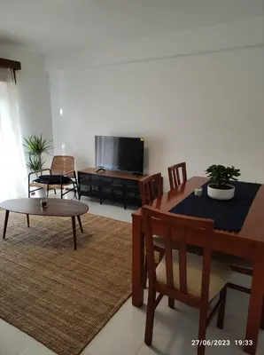 a living room with a table and a tv at The Retreat - O Retiro Algarvio in Faro