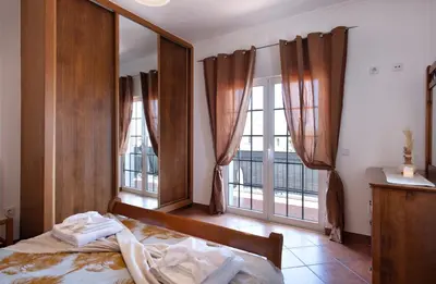 a bedroom with a bed and two large windows at Villa Luz Vieira in Albufeira