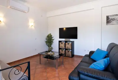 a living room with a couch and a tv at Villa Luz Vieira in Albufeira