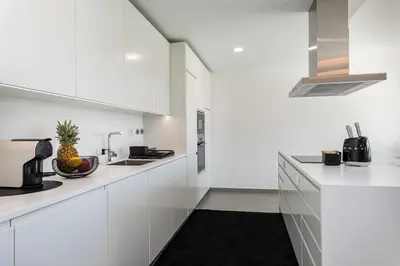 a white kitchen with white cabinets and a pineapple on the counter at The Albufeira Concierge - Prime Lounge Design in Albufeira
