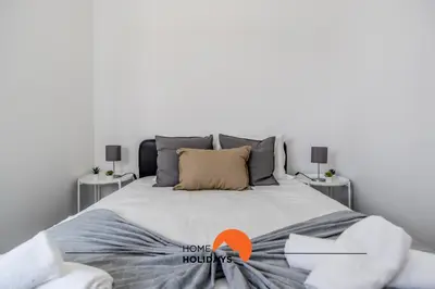 a bedroom with a large bed with two tables at #163 Dr José Silva 17 by Home Holidays in Albufeira