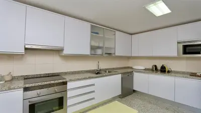 a kitchen with white cabinets and a sink at Vila Mitri, Monte laguna-CleverDetails, 5 bedroom villa, sleeps 8 adults 2 children in Vilamoura