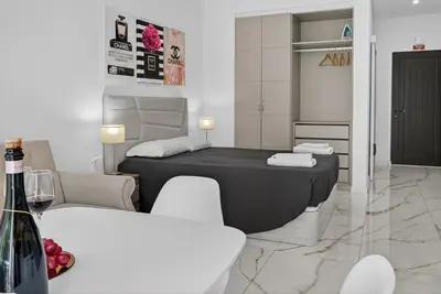 a room with a bed and a table and chairs at Estudio Balaia by Villas Key in Albufeira