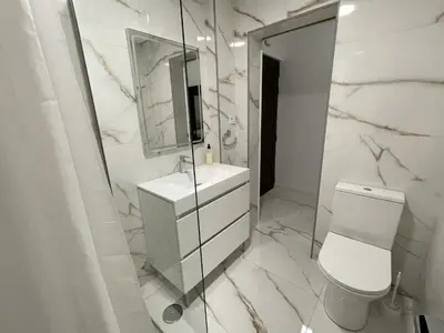 a bathroom with a toilet and a sink and a mirror at Estudio Balaia by Villas Key in Albufeira