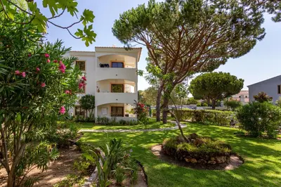 a house with a garden in front of it at Host Wise - Fresh Sunny Flat with Pool & Terrace in Olhos de Água