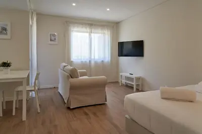 a living room with a table and a couch at LEGACY SUITES & APARTMENTS ALBUFEIRA AL - No Groups in Albufeira