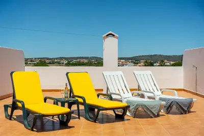 four yellow chairs and a table on a roof at Pine Trees Penthouse in Olhos de Água