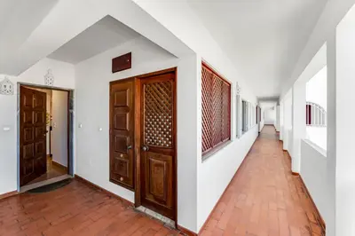 a corridor of a house with wooden doors at Pine Trees Penthouse in Olhos de Água