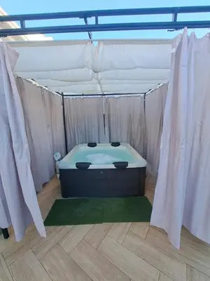 a hot tub in a tent with white curtains at Zurrinha holidays whit jacuzzi in Quarteira