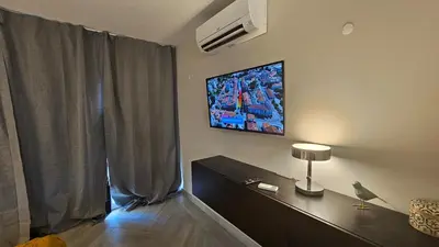 a living room with a television on the wall at Ocean View Beach Studio Old Town in Albufeira