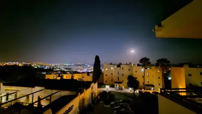 a view of a city at night with the moon at Ocean View Beach Studio Old Town in Albufeira