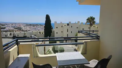 a balcony with a table and chairs and a view of a city at Ocean View Beach Studio Old Town in Albufeira