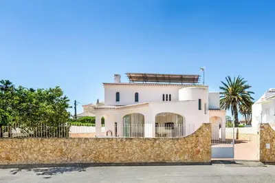 a white bedroom with a bed and a window at Villa Vivienda Jade in Galé