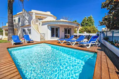 a villa with a swimming pool in front of a house at Villa Crispa in Albufeira