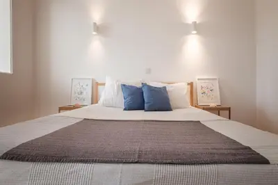 a bedroom with a large bed with blue pillows at Sunny Days beach apartment in Quarteira