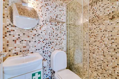 a bathroom with a toilet and a sink and a shower at Apartamento Estrela do Mar in Quarteira