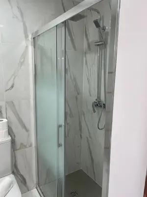 a shower with a glass door in a bathroom at A Minha Praia in Quarteira