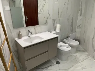 a bathroom with a sink and a toilet and a mirror at A Minha Praia in Quarteira