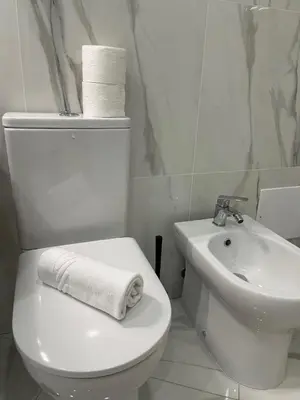 a white bathroom with a toilet and a sink at A Minha Praia in Quarteira