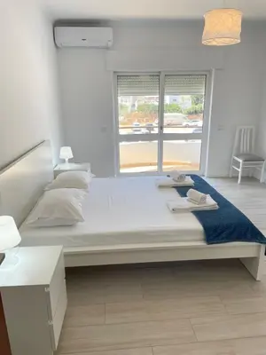 a large bed in a room with a window at A Minha Praia in Quarteira