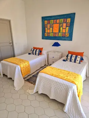a room with two beds and a painting on the wall at Seaside SunFlower in Quinta do Lago