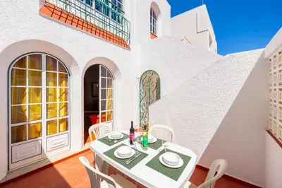 an exterior view of a white building with plants at Villa Lili in Albufeira