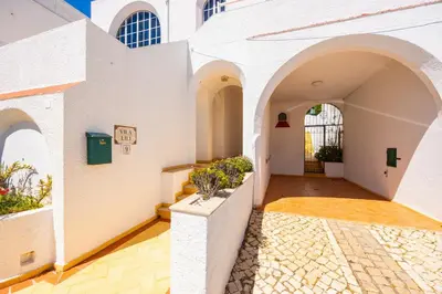 an internal courtyard of a building with arches and plants at Villa Lili in Albufeira