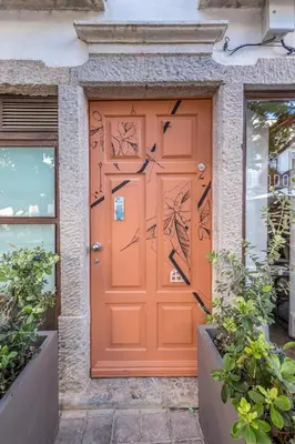 an orange front door of a house at LODO Suites Arco - Mezanino apartment by HD in Faro