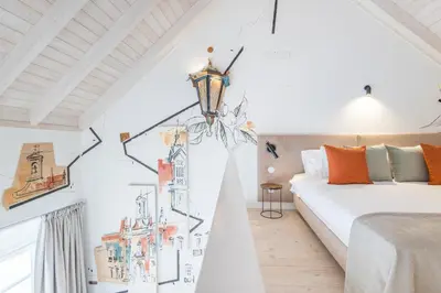 a bedroom with a bed and a wall with drawings on it at LODO Suites Arco - Mezanino apartment by HD in Faro