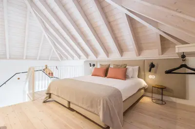 a bedroom with a large bed and a wooden ceiling at LODO Suites Se - Mezanino room by HD in Faro